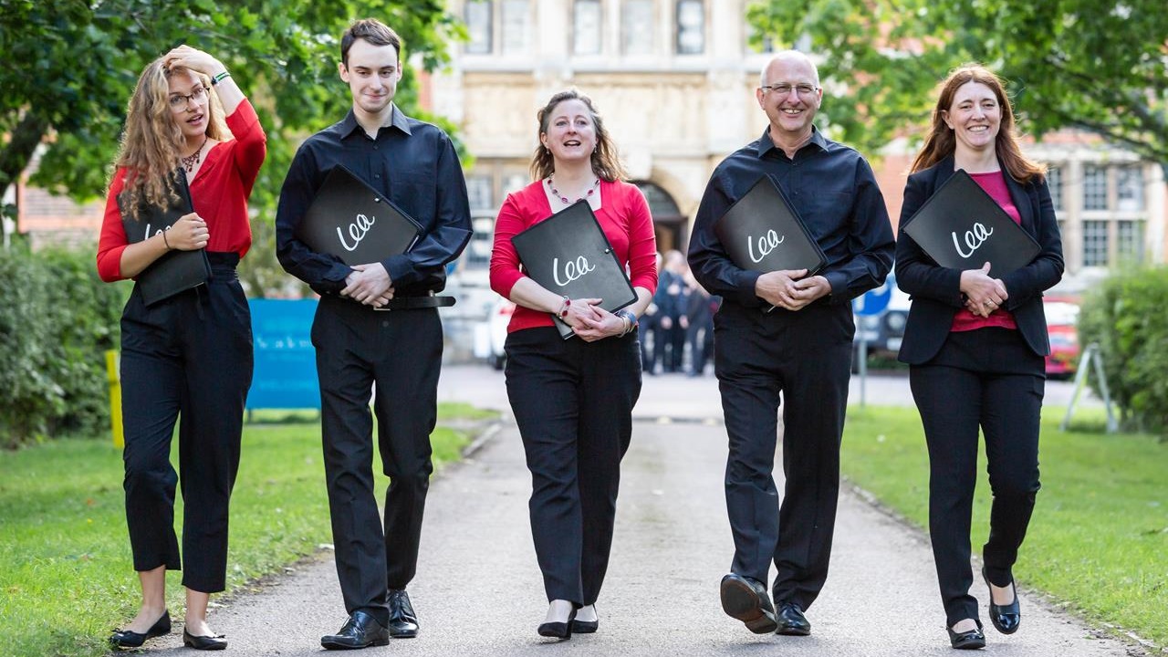 Five members of the Lea Singers choir walking along the driveway of Academy St Albans in 2019