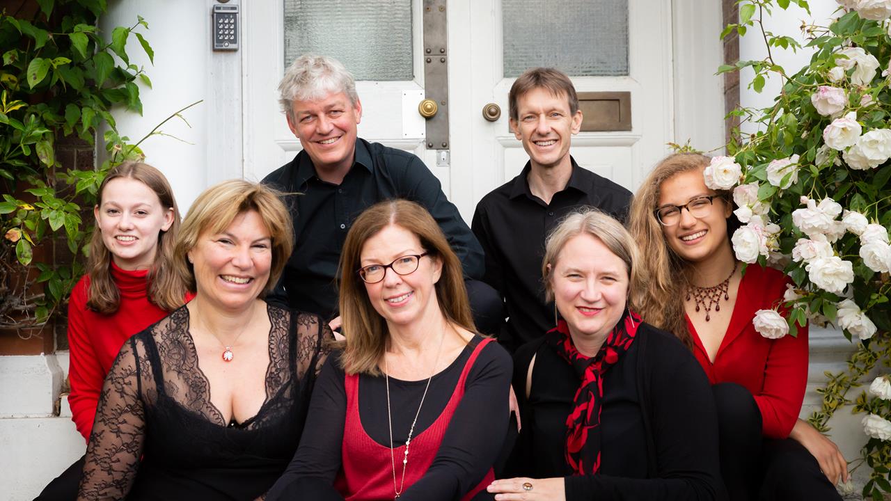 Seven members of the Lea Singers choir sitting on steps at Academy St Albans in 2019
